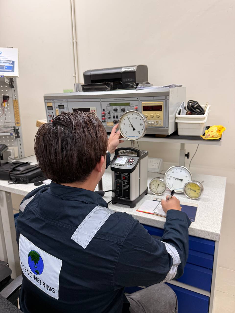 PIC Engineering technician verifying a pressure gauge on the calibration bench
